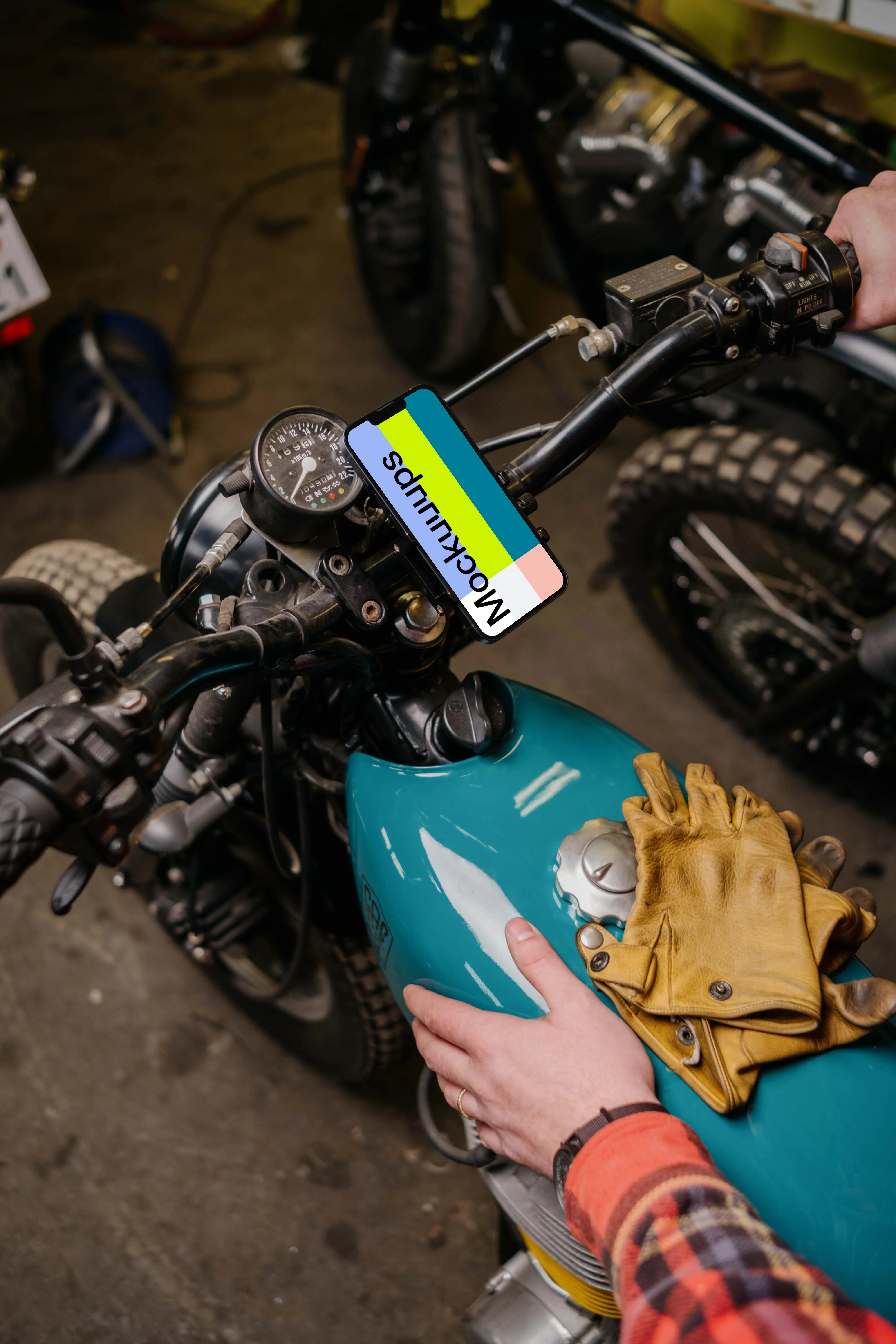 Man with a motorcycle holding an iPhone 13 Mockup