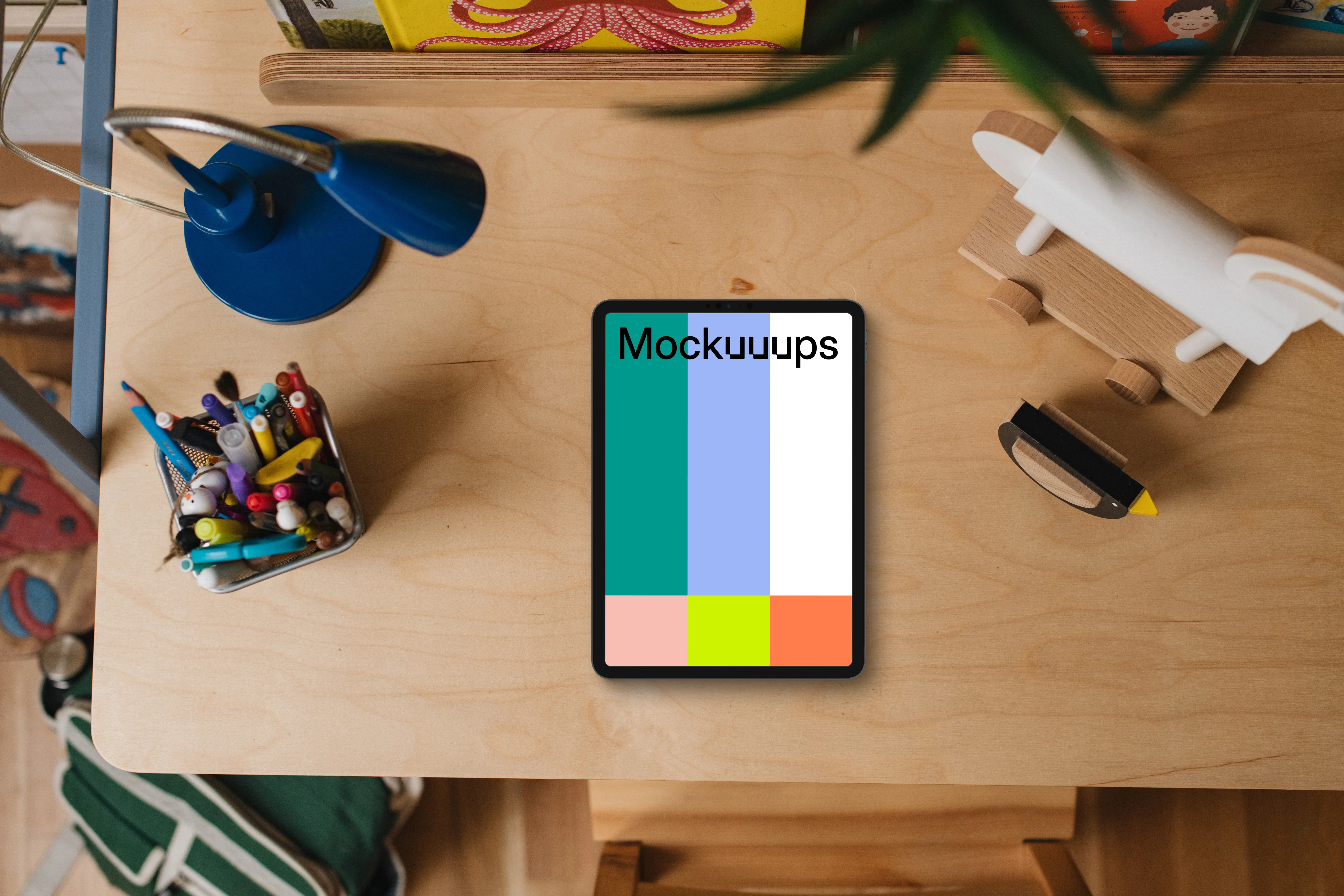 Tablet mockup on a child's desk with toys