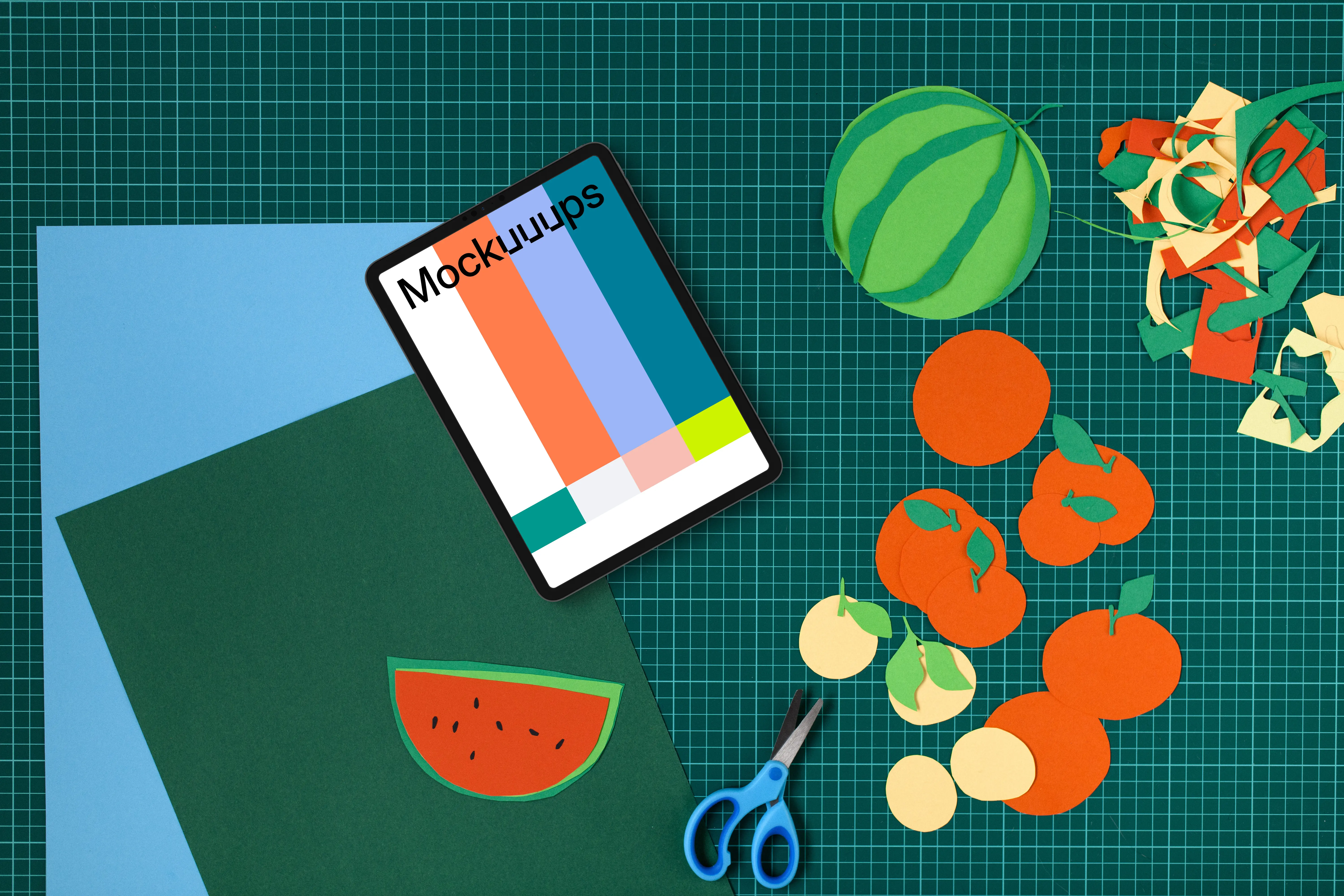 Tablet mockup on a colorful craft table with cut-out fruits
