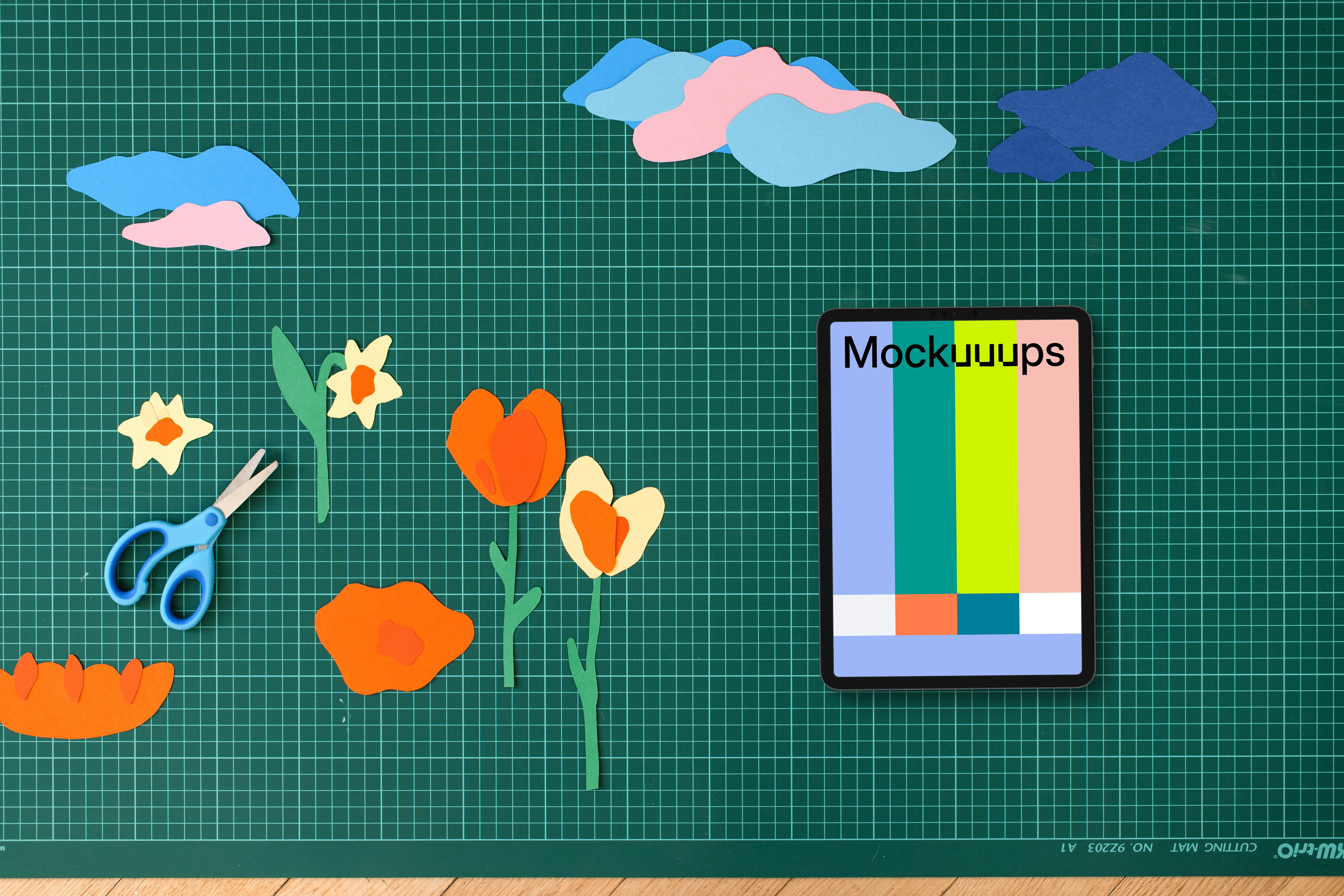 Tablet mockup on a crafting table with paper decorations