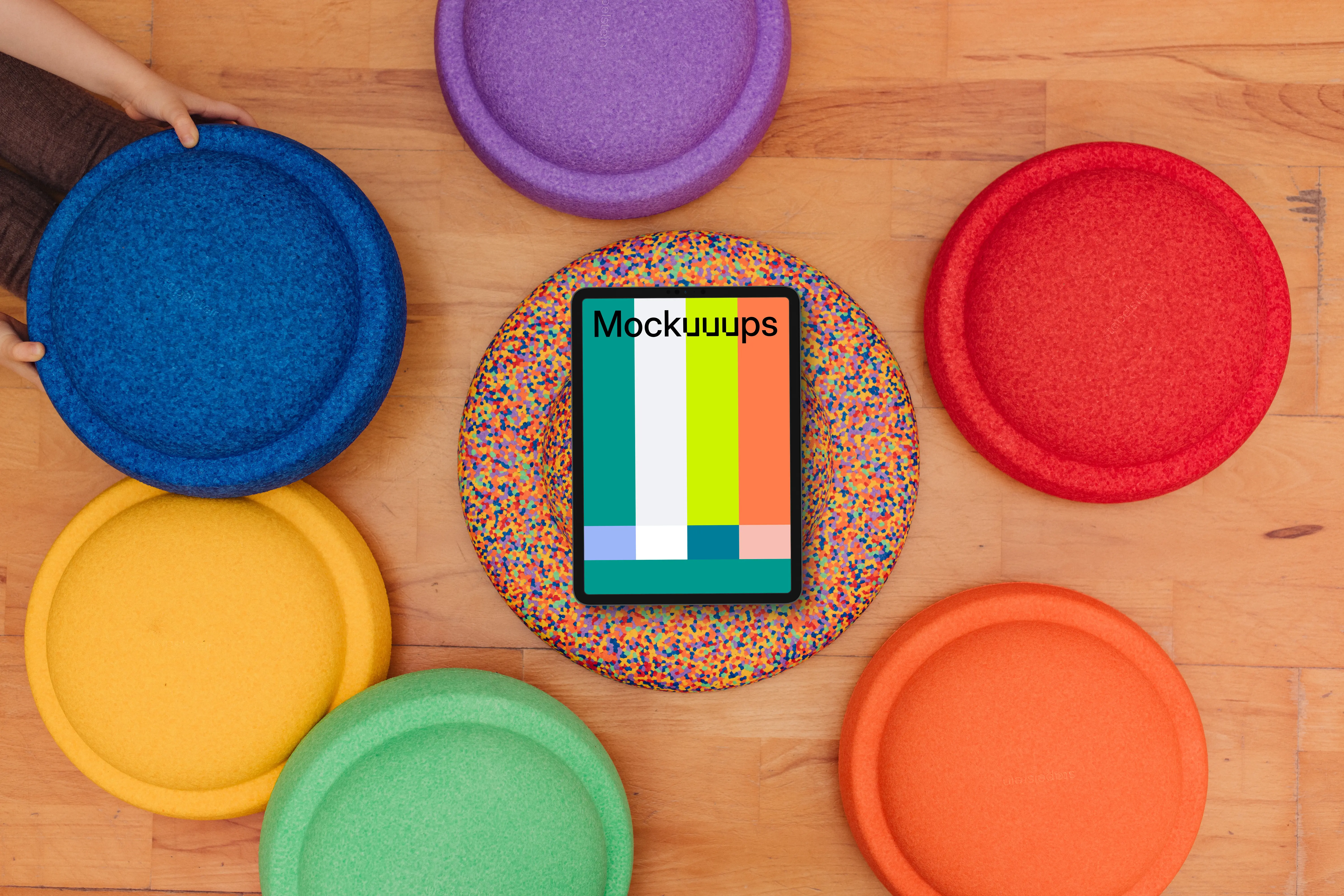 Tablet mockup surrounded by colorful kids seat cushions