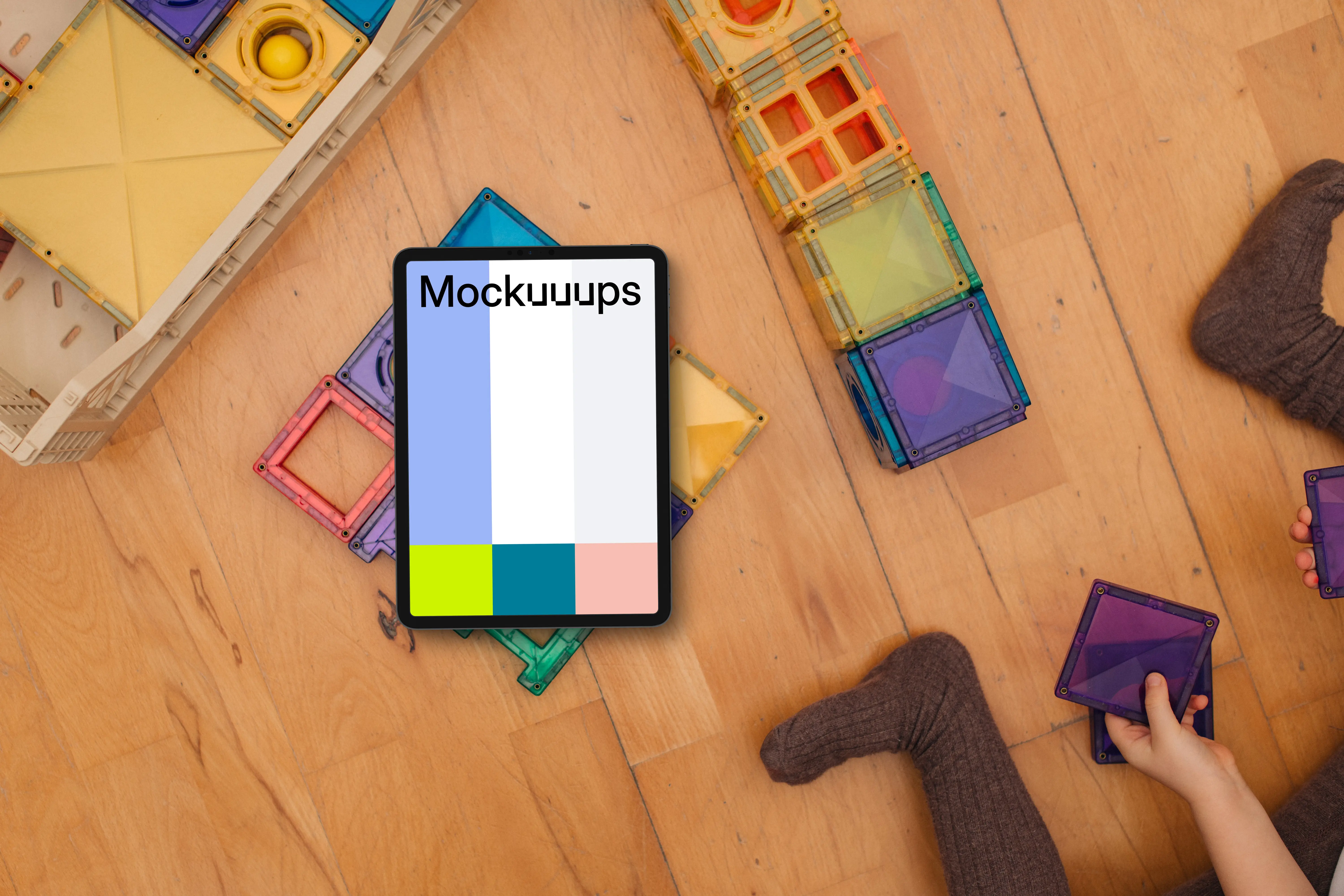 Tablet mockup with colorful building blocks and children's hands