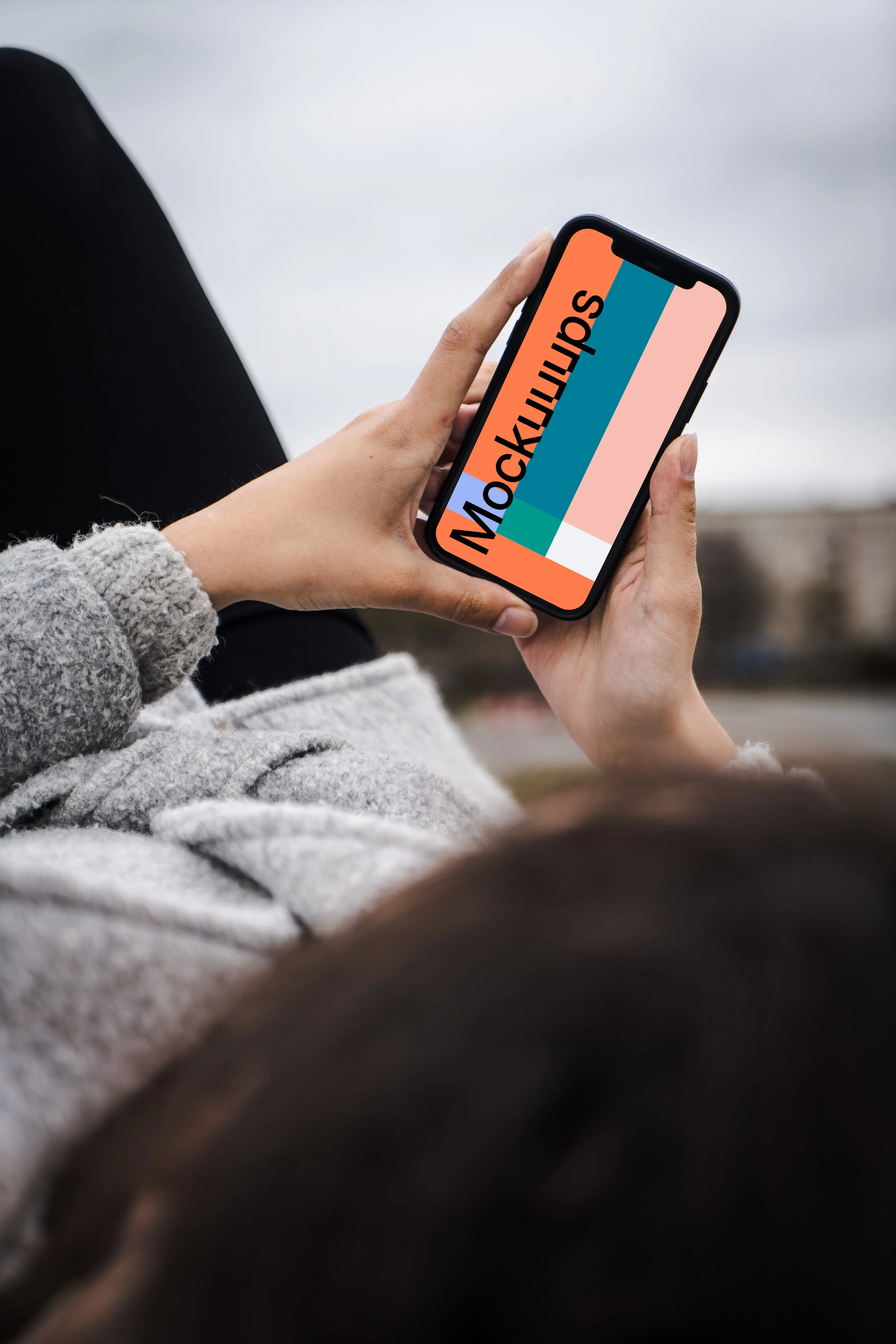 Woman holding a phone mockup in both hands