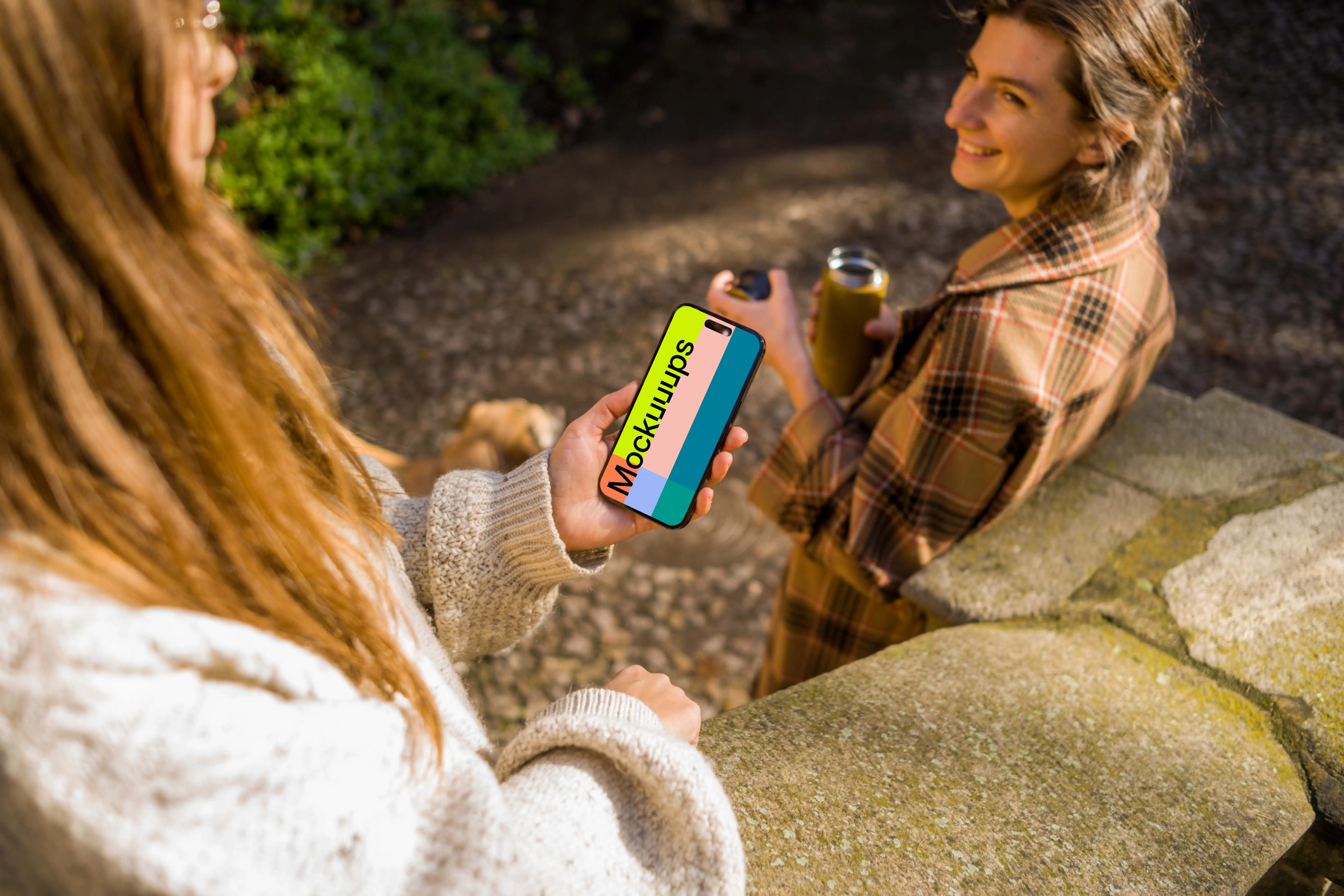 Woman holding an iPhone 14 Pro next to the friend mockup