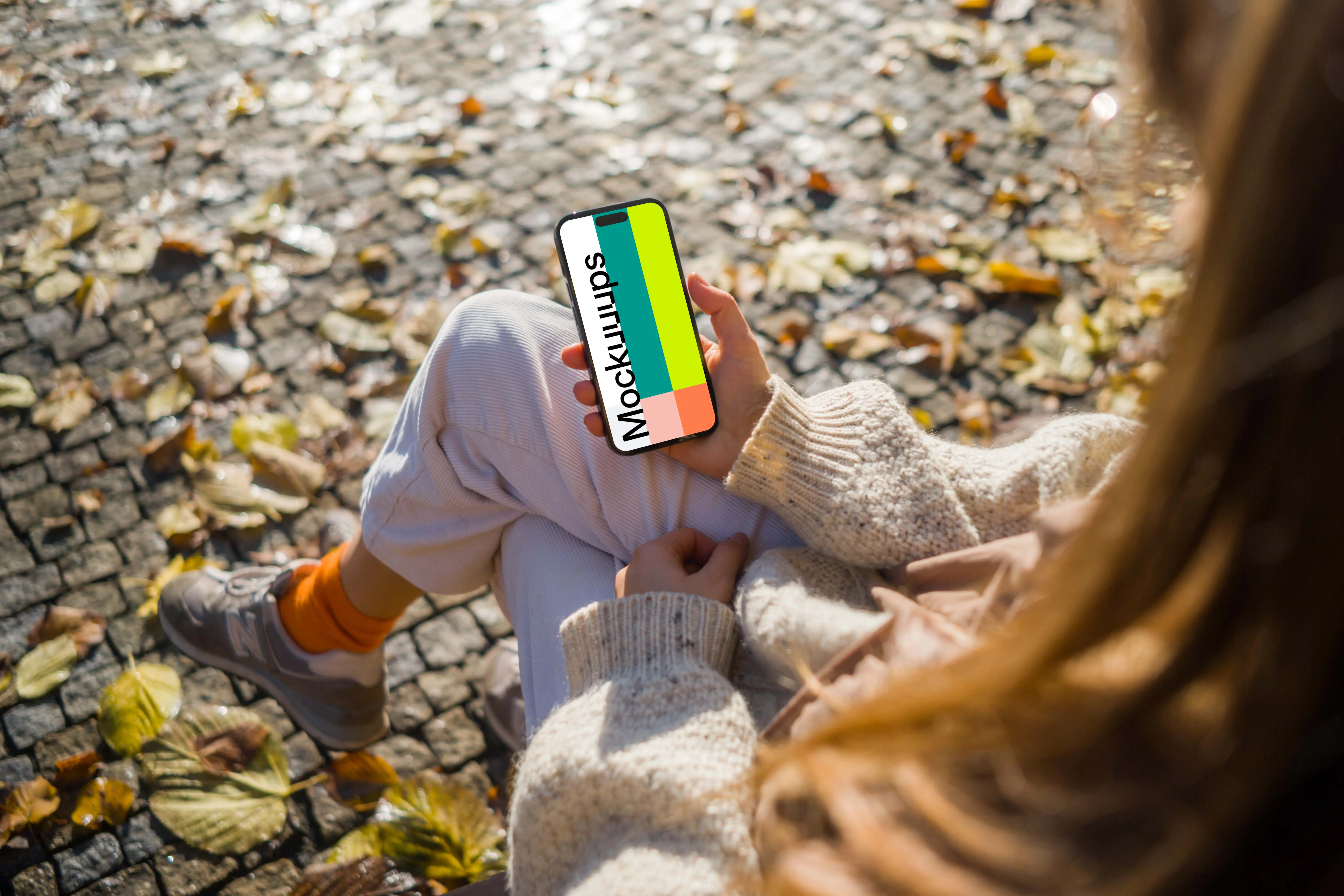 Woman holding an iPhone in autumn theme mockup