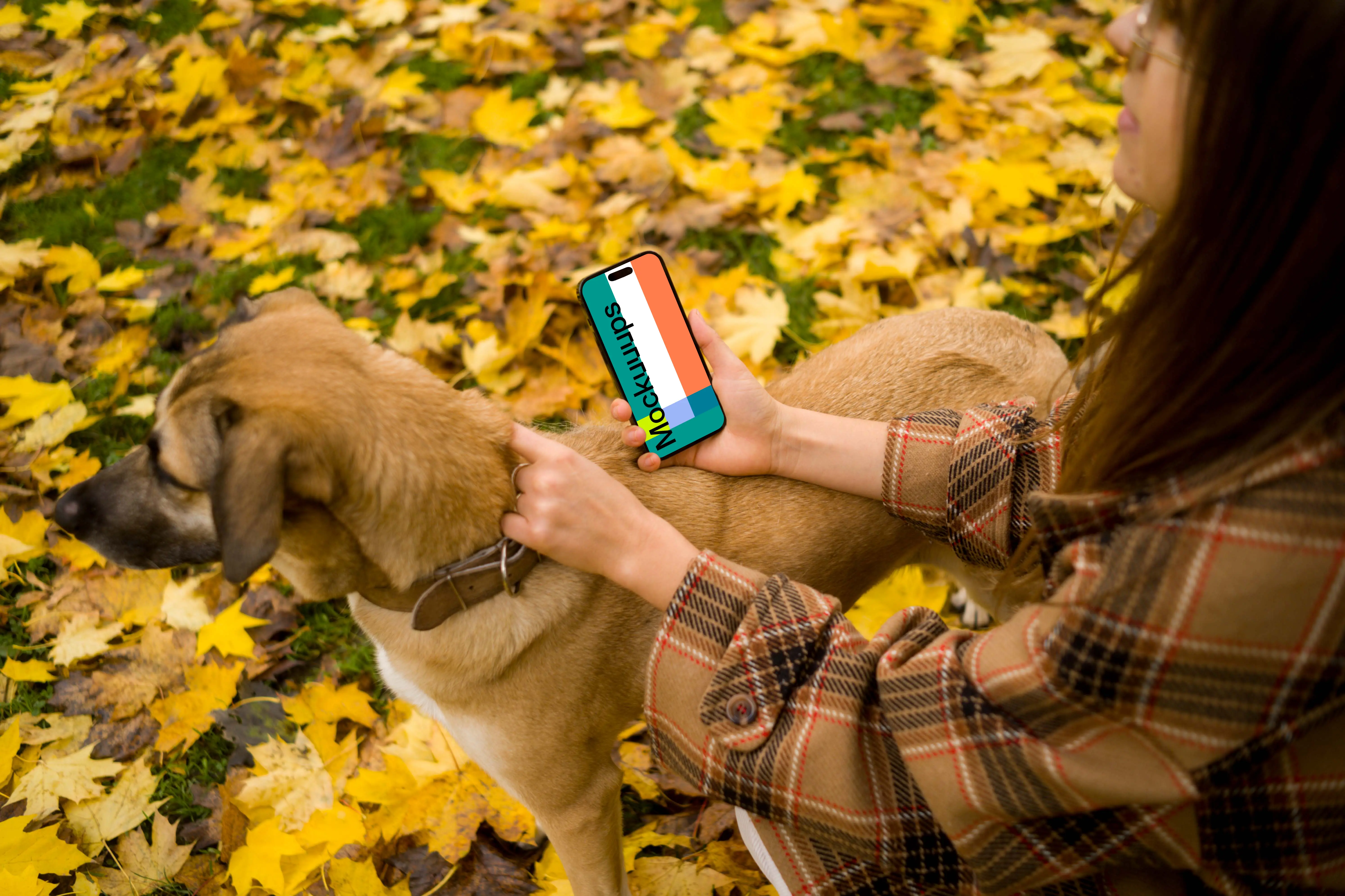 Woman holding an iPhone while scratching a dog in autumn mockup