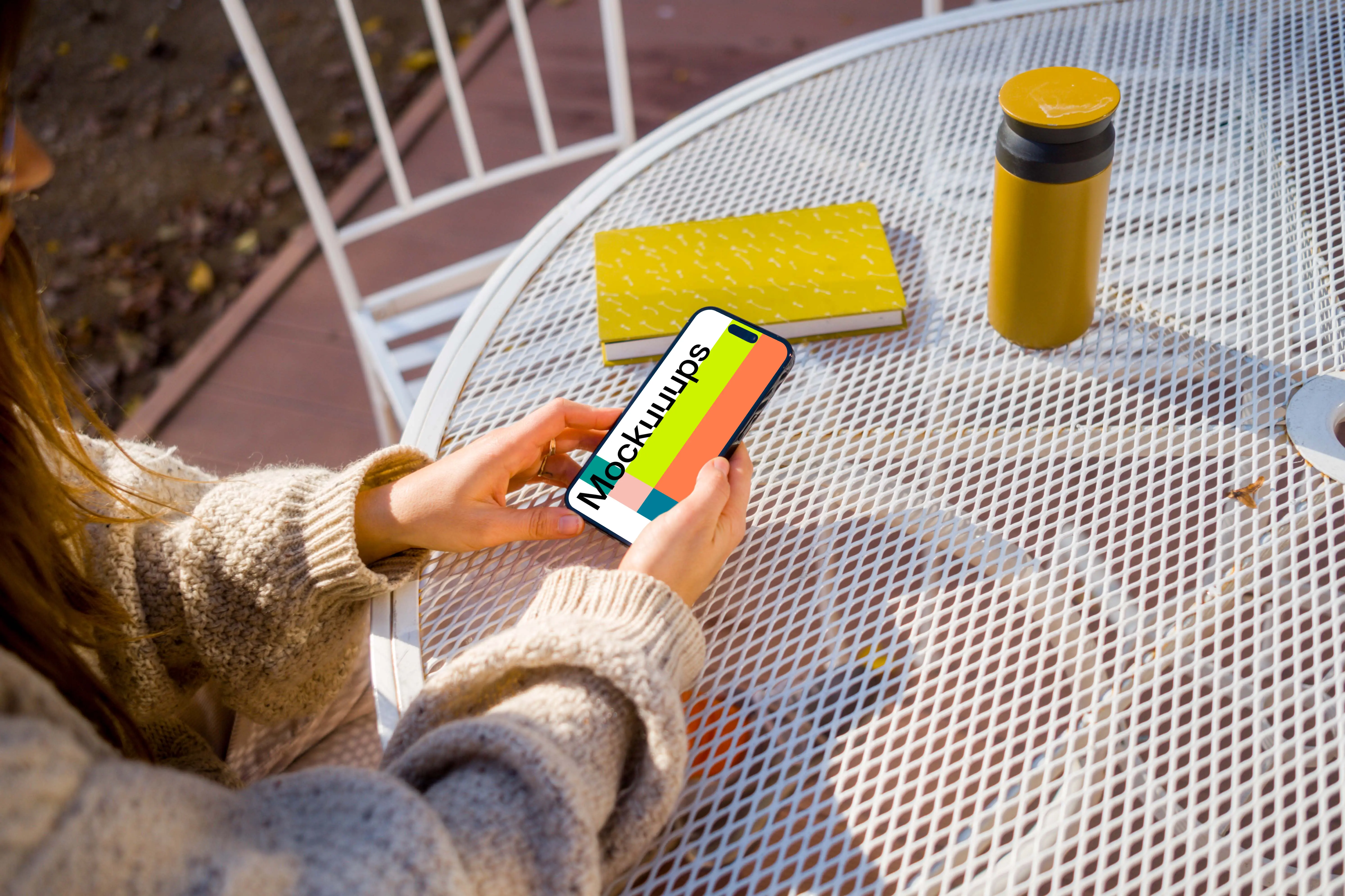 Woman in sweater holding an iPhone mockup