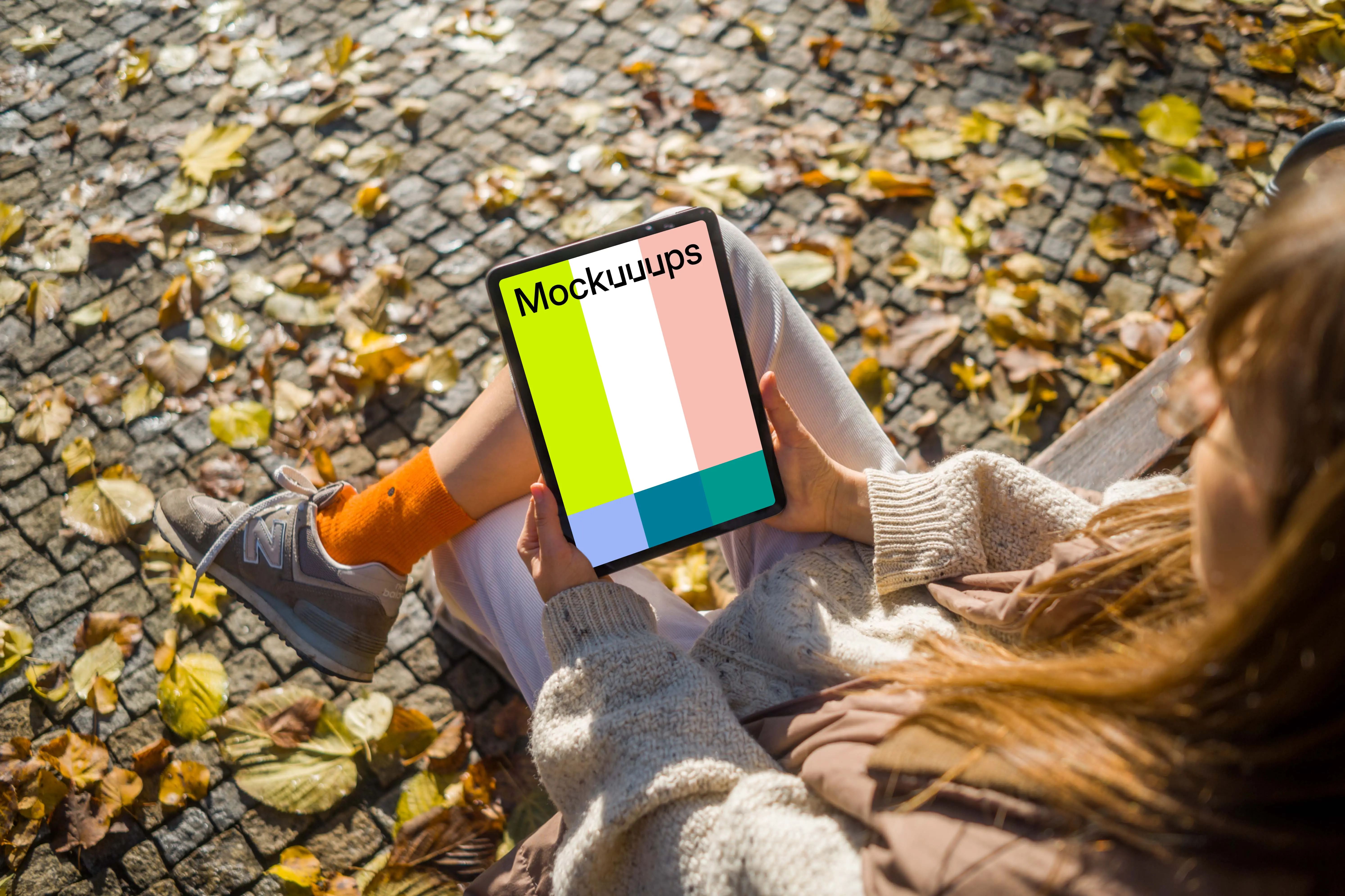 Woman sitting on a bench holding an iPad Air mockup