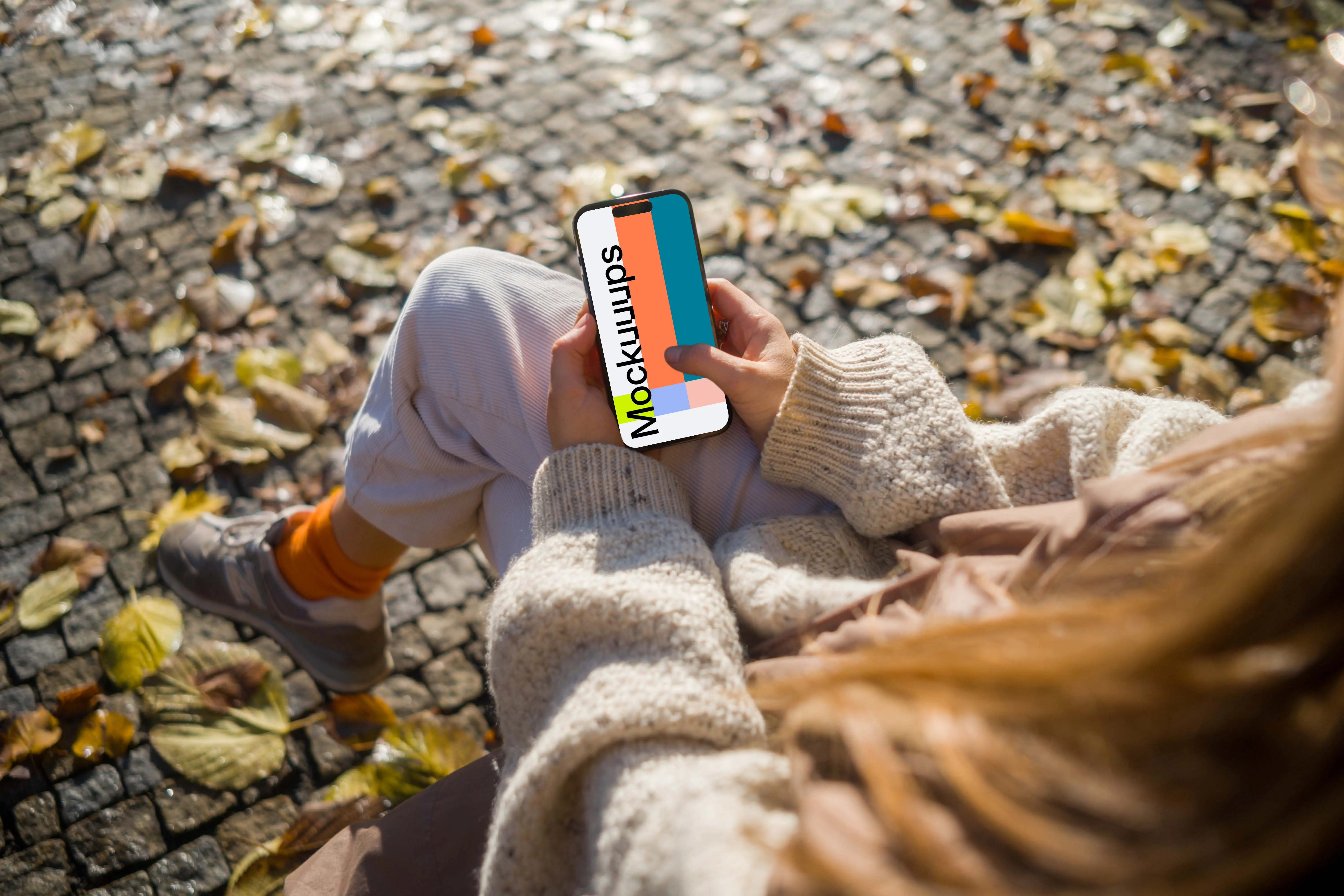 Woman typing on an iPhone 14 Pro in autumn park mockup