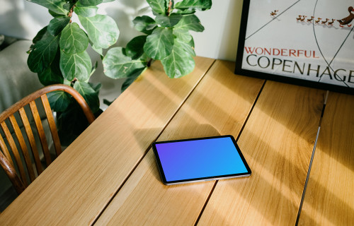 iPad Air mockup on a dining table in front of a framed photo 