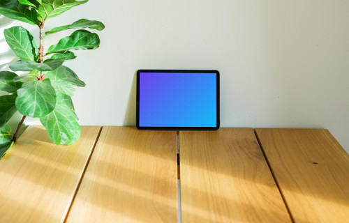 iPad Air mockup on a table leaning against a wall