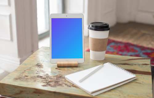iPad Mini mockup beside a cup of coffee and a notepad
