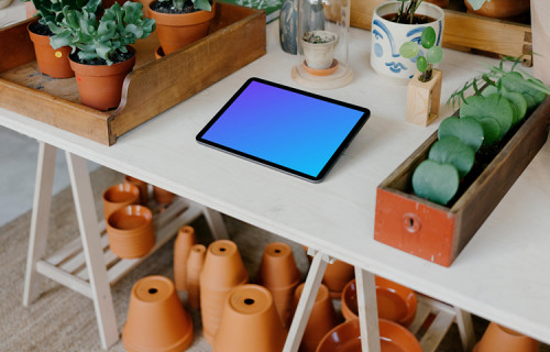 iPad mockup on a table with plant vases under the table
