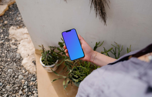 iPhone 13 Pro mockup held by a user outdoors