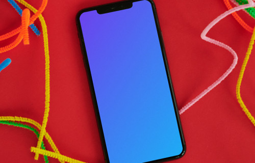 iPhone mockup on a red table