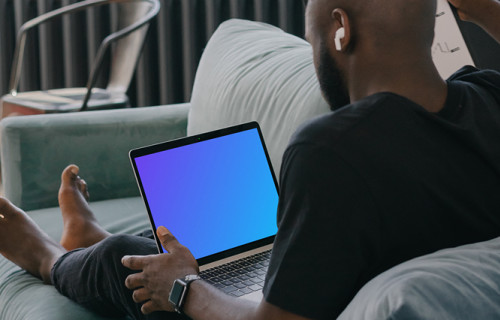 MacBook Air mockup in use by a man on a couch