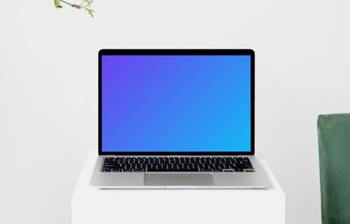 MacBook mockup on a tall white stool with wooden chair arm on the side