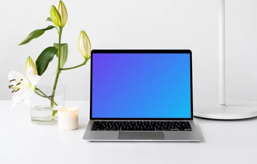 MacBook mockup on a white table with white table lamp at the side