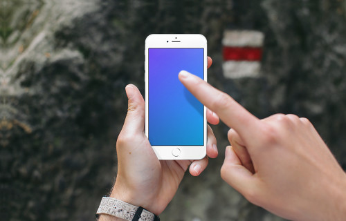 Pointing on iPhone 6s mockup in front of a Tourist Sign