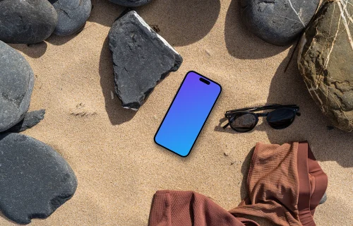 Smartphone mockup on a sandy beach with rocks