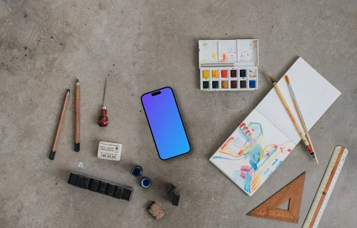 Top view of smartphone mockup next to the painting accessories