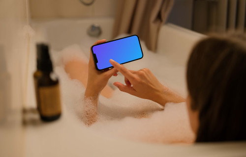 Woman hand typing on an iPhone 13 mockup