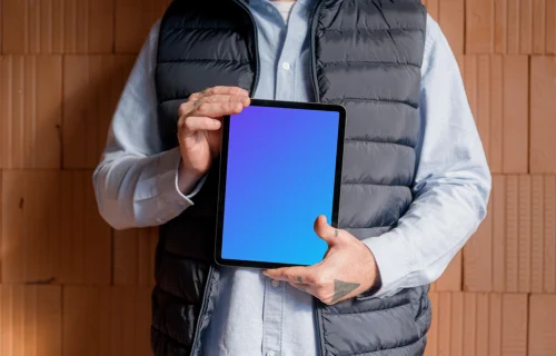 Un obrero de la construcción sostiene con confianza un iPad mockup