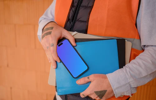 Trabajador de la construcción presentando un iPhone 15 Pro mockup