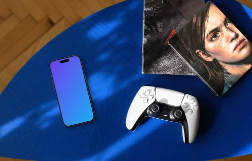 Gaming smartphone mockup with controller and artwork on blue table