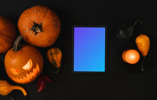 Calabaza de Halloween mockup con una tableta y velas