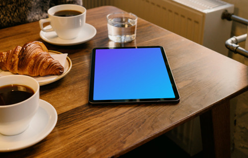 iPad Air mockup on a brown table with a plate of food at the side