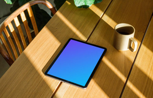 iPad Air mockup on a wooden table beside a coffee mug