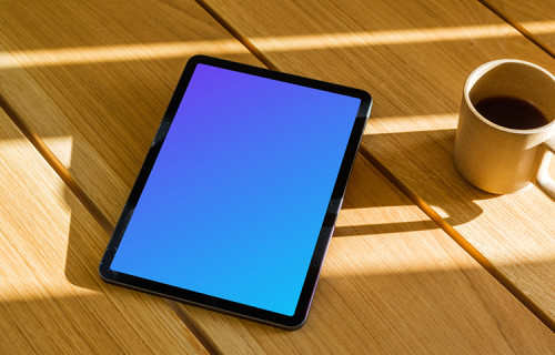 iPad Air mockup on a wooden table beside a mug of coffee