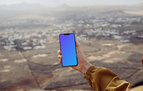 iPhone 13 Pro mockup held by a user above a field