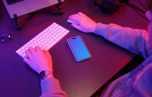 iPhone 15 Pro mockup in a neon-lit gaming setup