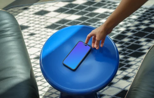 iPhone 15 Pro mockup with female hand on a blue stool
