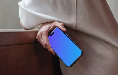 iPhone 16 mockup held by a person near a concrete surface