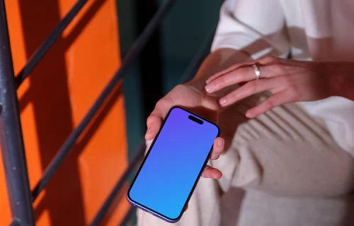 iPhone 16 mockup in a casual hand on concrete stairs