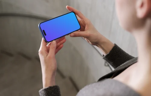 iPhone 16 mockup in a hand against concrete backdrop