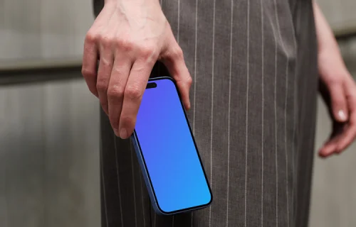 iPhone 16 mockup in hand with pinstripe pants