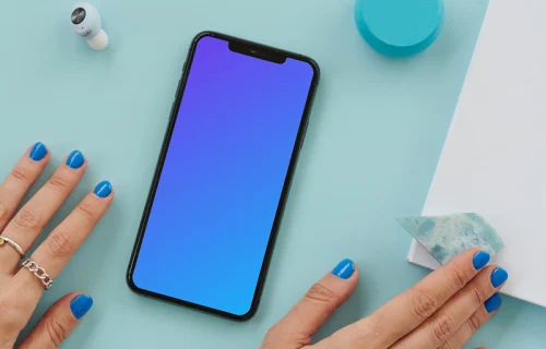  iPhone mockup on a blue table beside a pair of earbuds