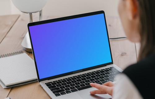 MacBook Air mockup in use by a lady with a notepad at the side