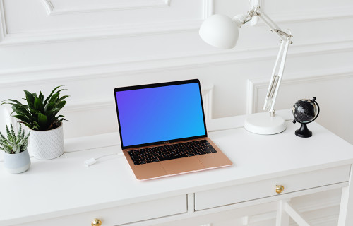 MacBook Air mockup sur une table avec un globe sur le côté