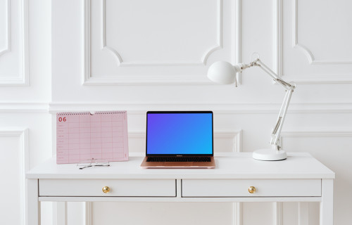 MacBook Air mockup sur une table avec un calendrier rose sur le côté