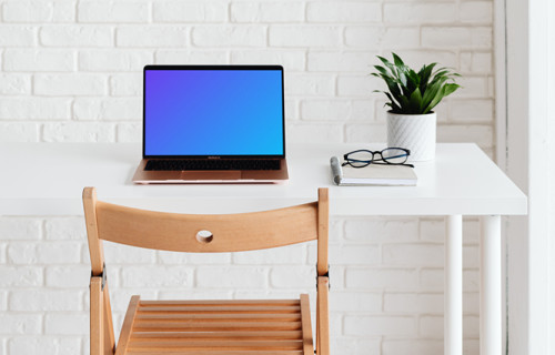 MacBook Air mockup with a notebook and pair of glasses at the side