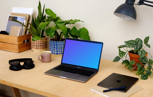 Macbook Pro mockup on a table beside a pair of headphones