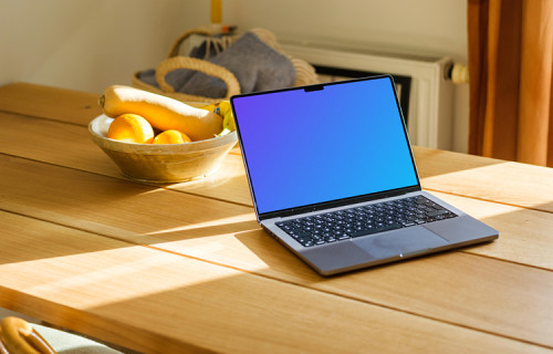 MacBook Pro mockup on a table with photo frames in the background