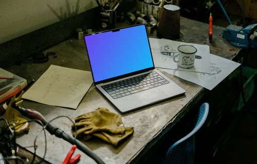 MacBook Pro mockup placed on a table beside work gloves