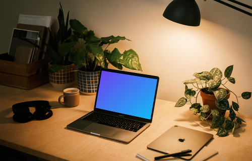 MacBook Pro mockup with a notepad and iPad Air at the side