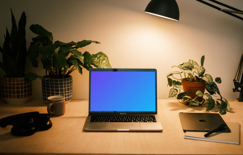 MacBook Pro mockup with a pair of headphones at the side